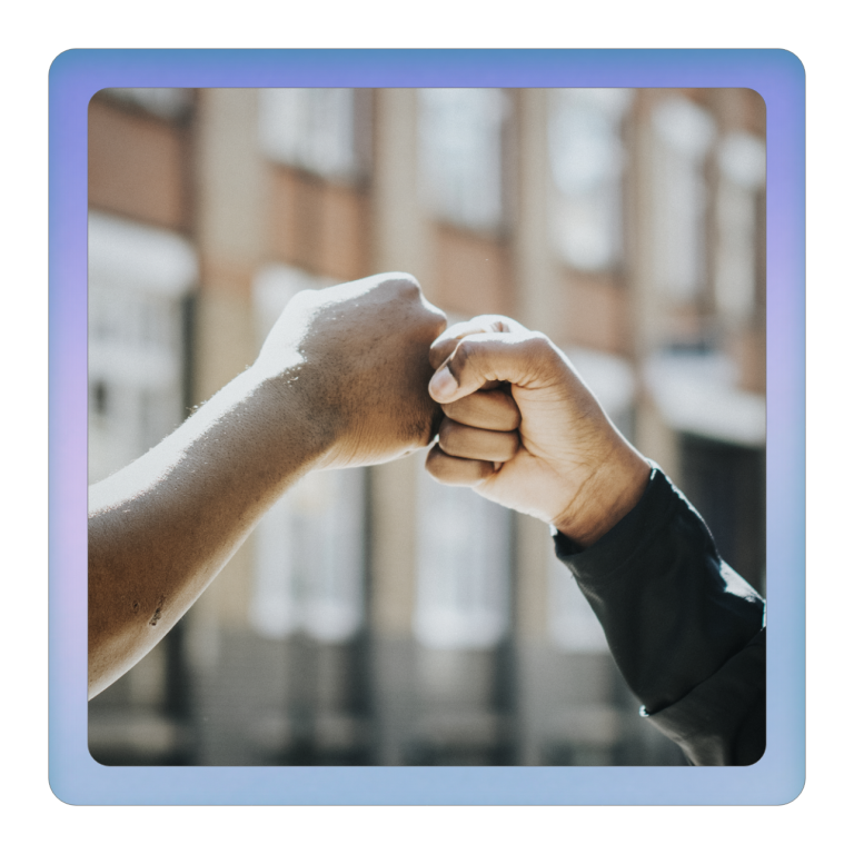 Marktwert steigern Zwei Hände treffen sich zum Fistbump vor einem unscharfen Hintergrund.